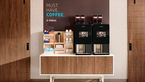 A coffee station with a sign that reads "MUST HAVE COFFEE." and displays various coffee makers and containers. - Holiday Inn Express Pittsburgh North by IHG (Pittsburgh)