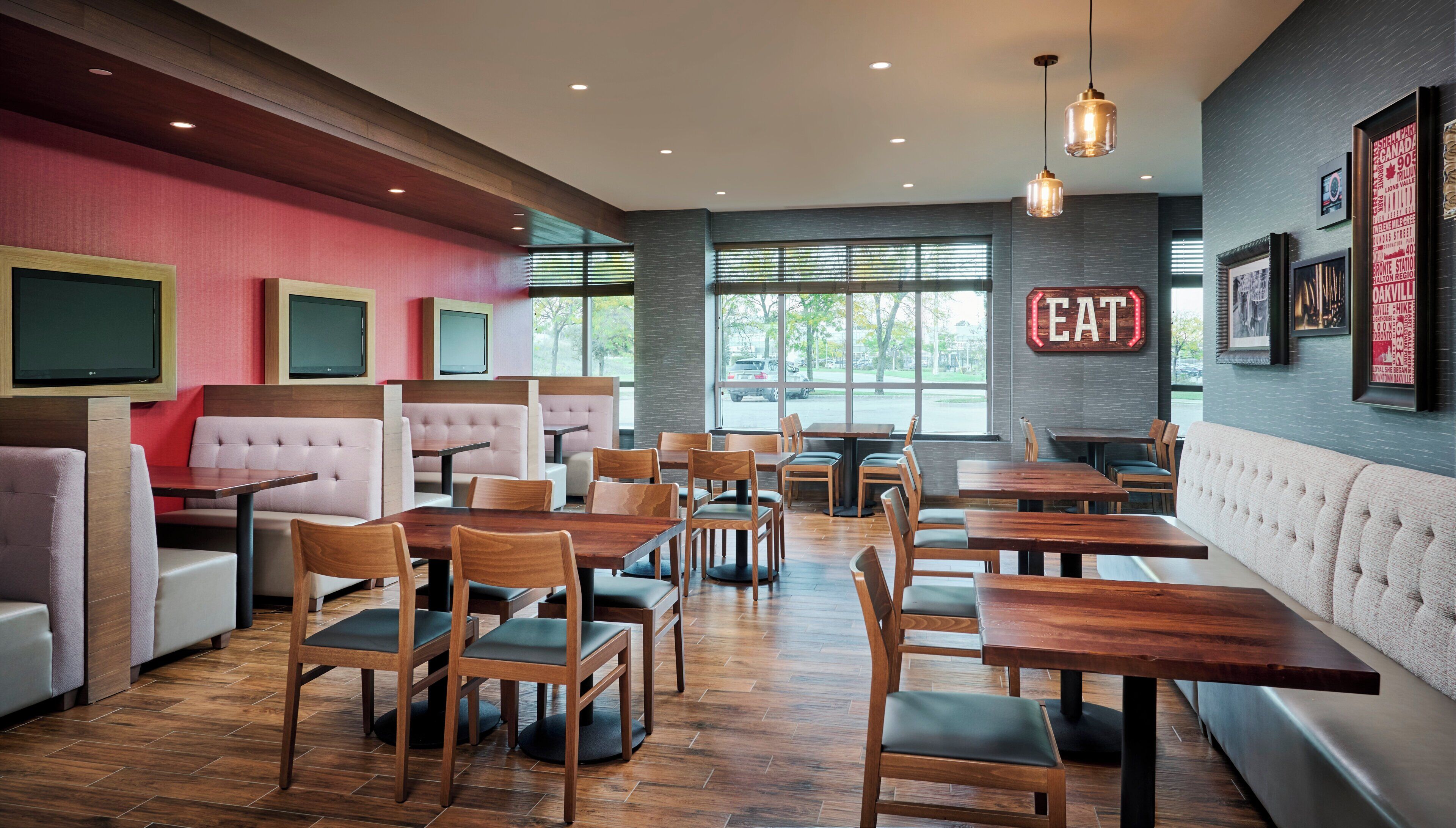 A restaurant interior with booths, tables, and a 'EAT' sign.