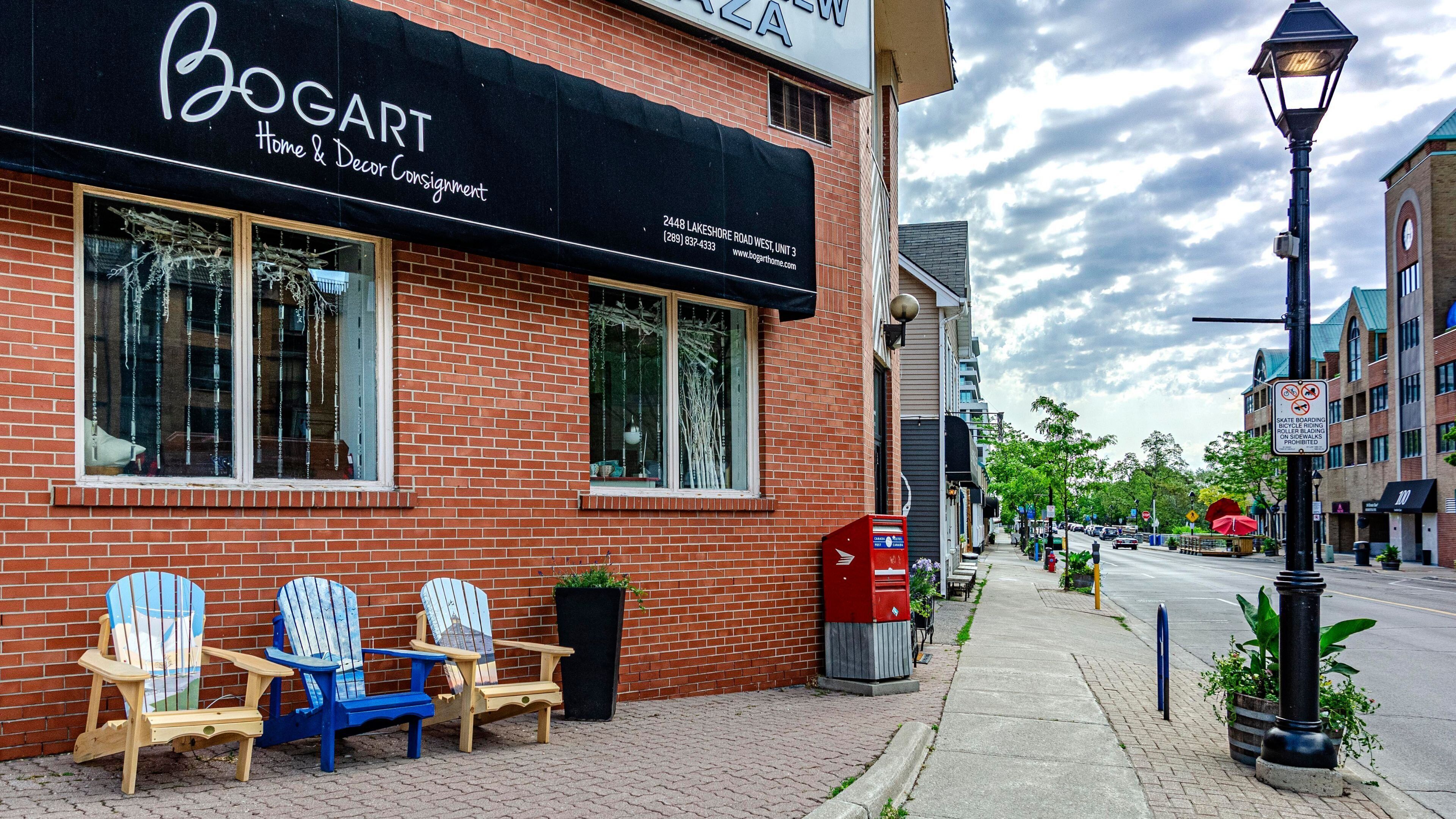 Un edificio de ladrillo con un toldo negro que dice 'BOGART Home & Decor Consignment'.