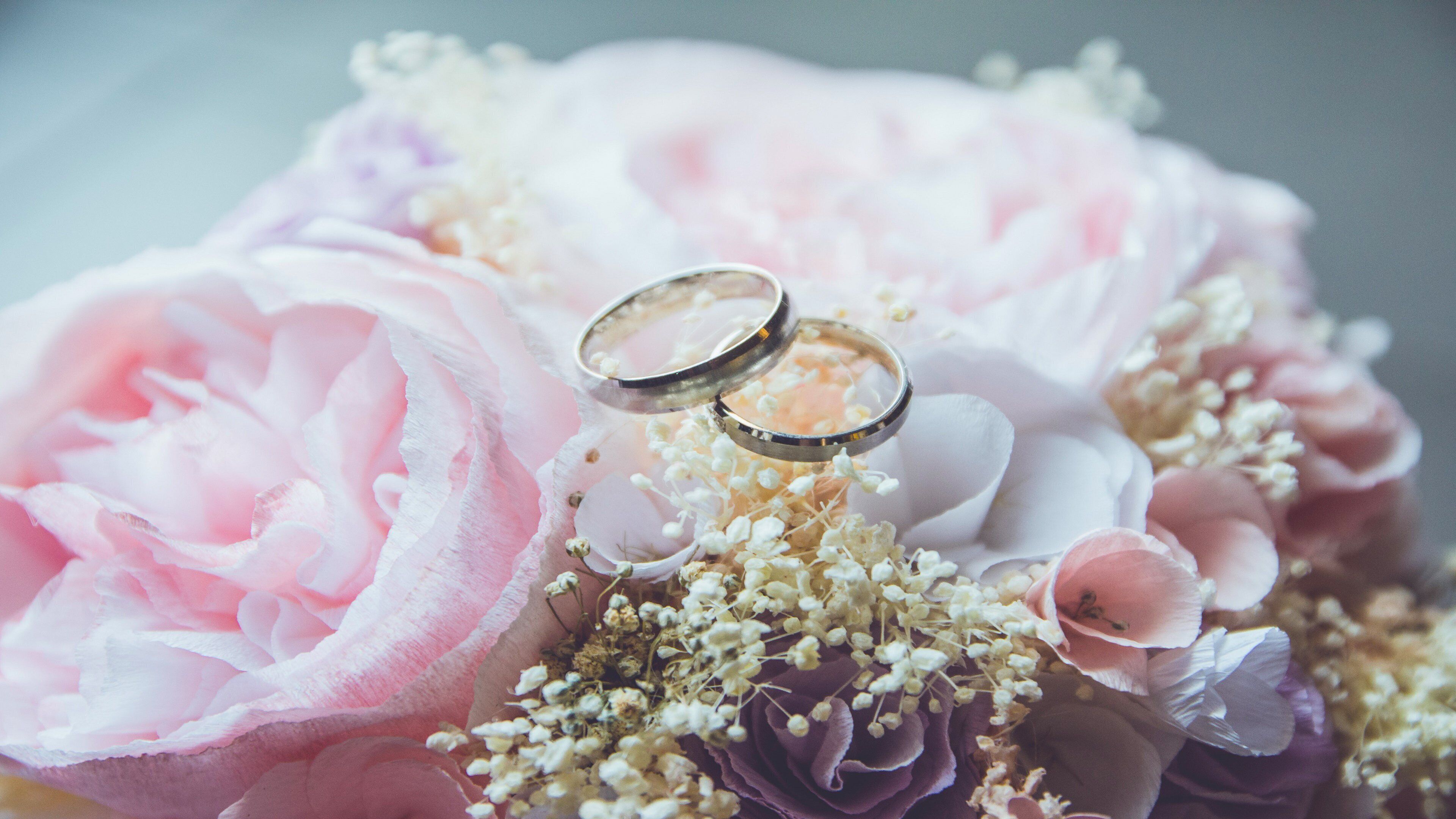 A bouquet of flowers with two rings placed on top.