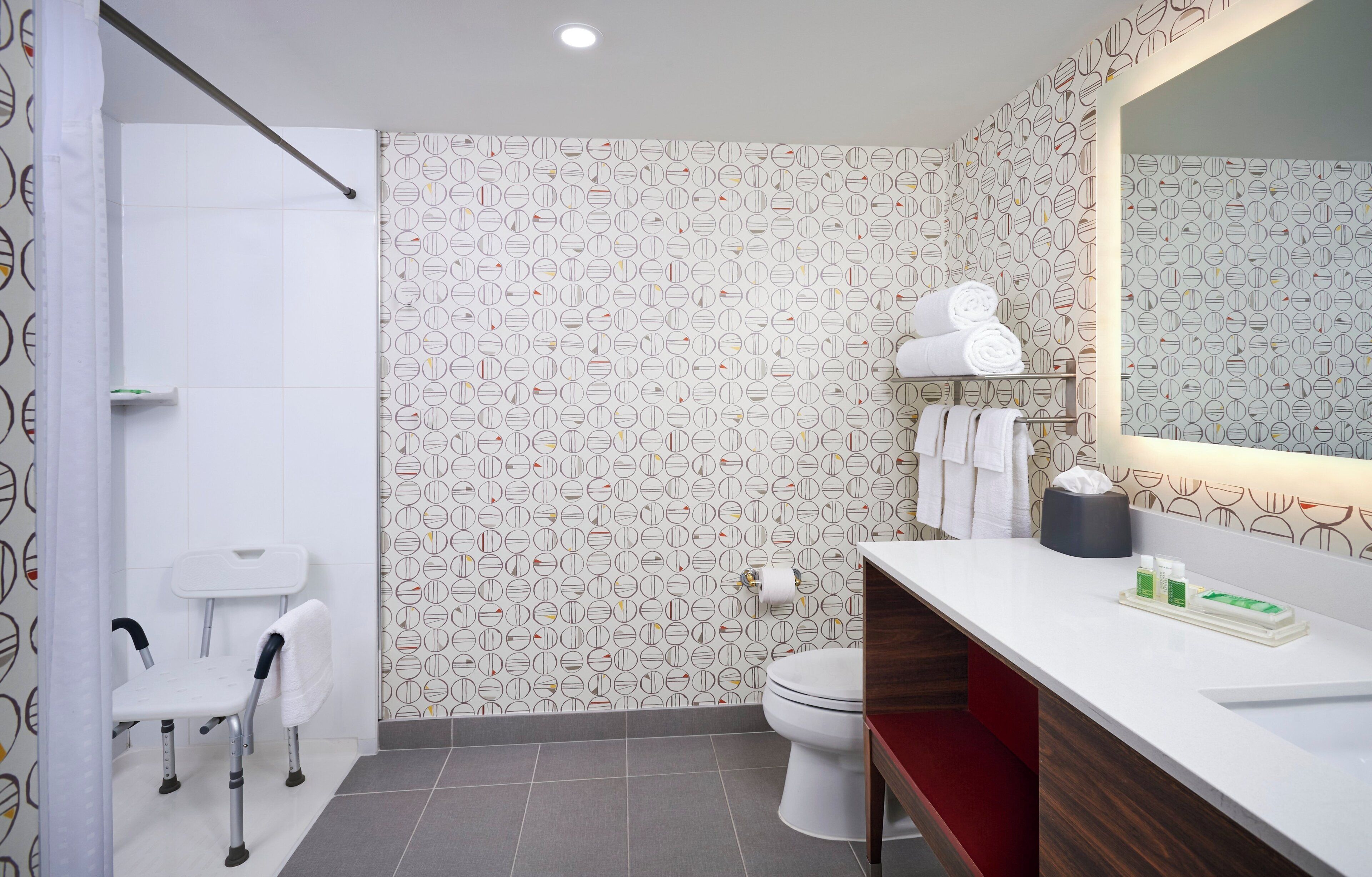 Une salle de bain moderne équipée d’une douche, de toilettes et d’un meuble-lavabo.