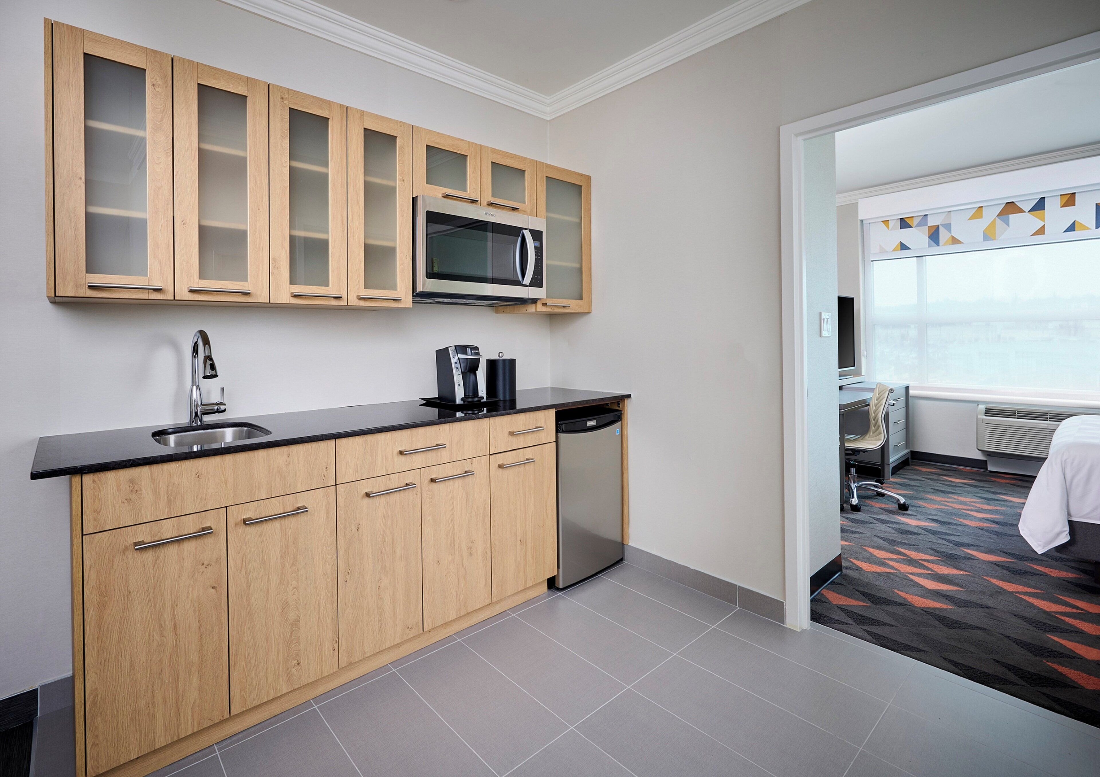 A modern kitchen with a microwave, coffee maker, and dishwasher.