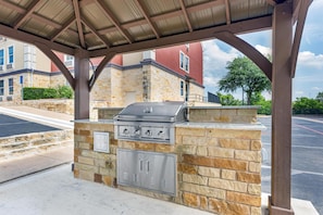 An outdoor grill area with stone walls and a metal roof structure. - Best Western Plus Georgetown Inn & Suites (Georgetown)