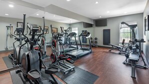 A gym with various exercise machines, a large mirror, and a television on the wall. - Best Western Plus Georgetown Inn & Suites (Georgetown)