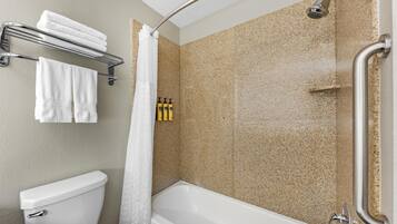 A bathroom with a toilet, a bathtub, a shower, and a towel rack.