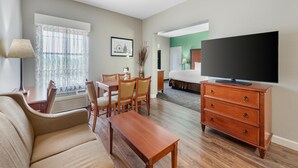 A hotel room with a living area, a dining table, a sofa, a TV, and a bed. - Best Western Plus Georgetown Inn & Suites (Georgetown)