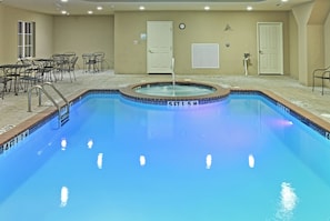 A swimming pool with a tiled edge, a lounge area with chairs, and a door marked 'POOL EQUIPMENT'. - Holiday Inn Express Hotel & Suites Kilgore by IHG (Kilgore)