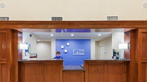 Bancada de recepção com parede azul e um sinal da Holiday Inn Express.