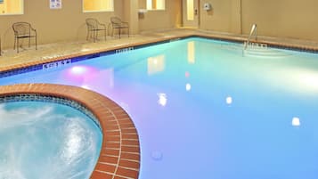 A swimming pool with a brick edge and a tiled deck area.