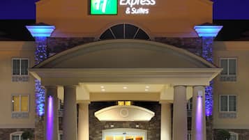A Holiday Inn Express & Suites building with a prominent entrance, columns, and a stone facade.