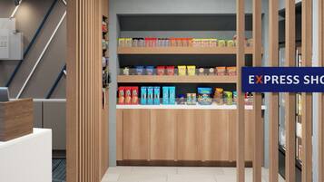 A modern interior with a wooden reception desk, a staircase, and a variety of snack products on shelves.