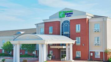 Un hotel Holiday Inn Express & Suites con fachada de ladrillo, entrada cubierta y estacionamiento.