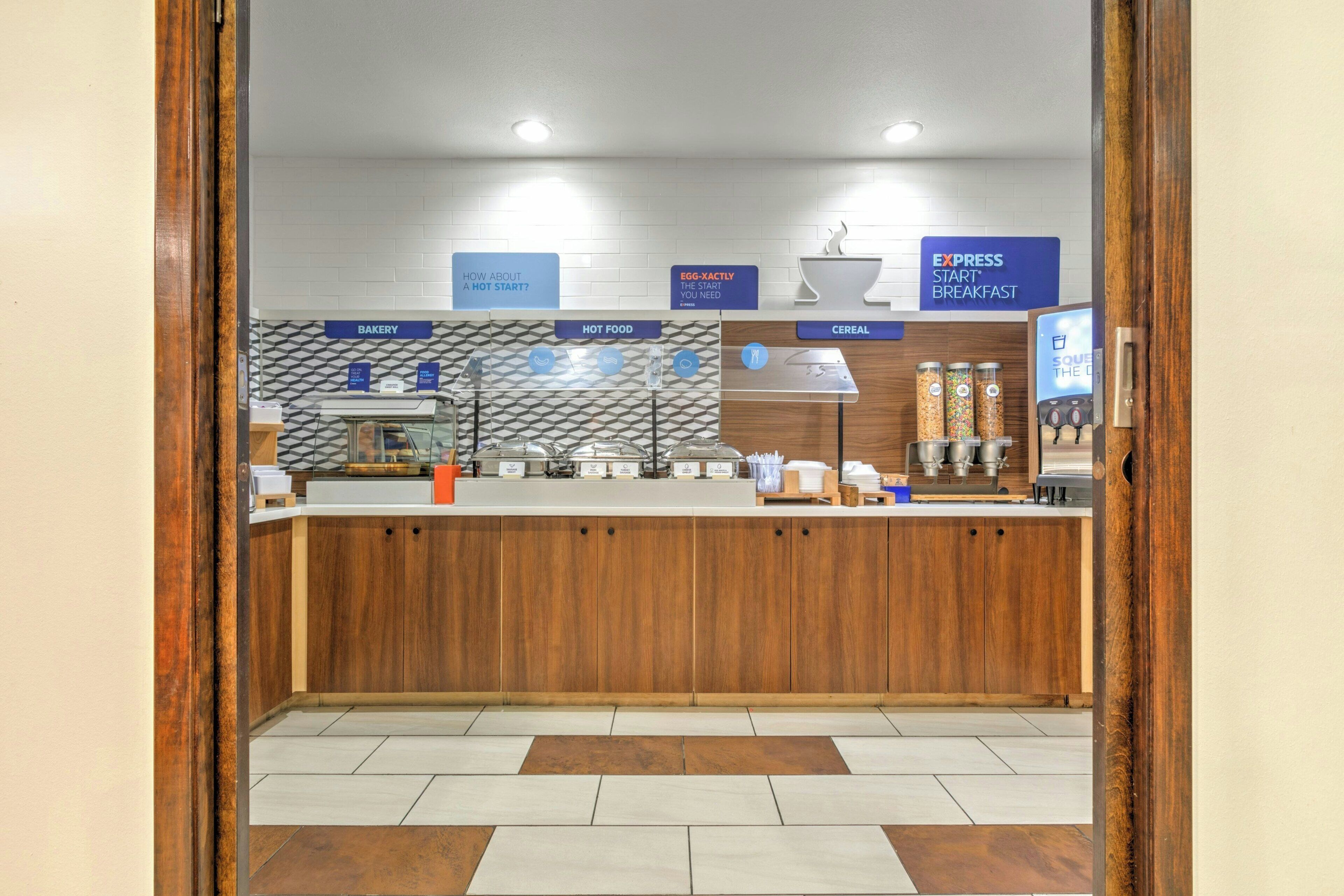 A breakfast counter with labeled sections for bakery, hot food, and cereal.