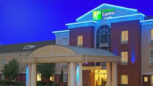 A Holiday Inn Express & Suites building with a covered entrance, brick facade, and illuminated signage. - Holiday Inn Express Hotel & Suites Livingston by IHG (Livingston)