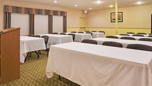 A conference room with multiple tables, chairs, a podium, and a door. - Holiday Inn Express Hotel & Suites Livingston by IHG (Livingston)
