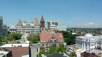 A cityscape with historic buildings, including a prominent red-roofed building with a clock tower and a white building with a dome.