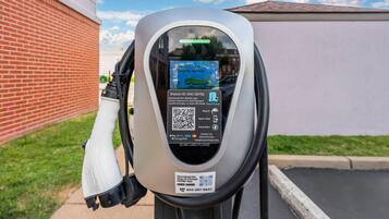 Un parquímetro con un código QR, instrucciones y un enlace para descargar una aplicación móvil.