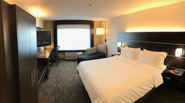 A hotel room with a large bed, a desk with a computer, a television, a sofa, and a window with a view. - Holiday Inn Express Hotel & Suites Tracy by IHG (Tracy)