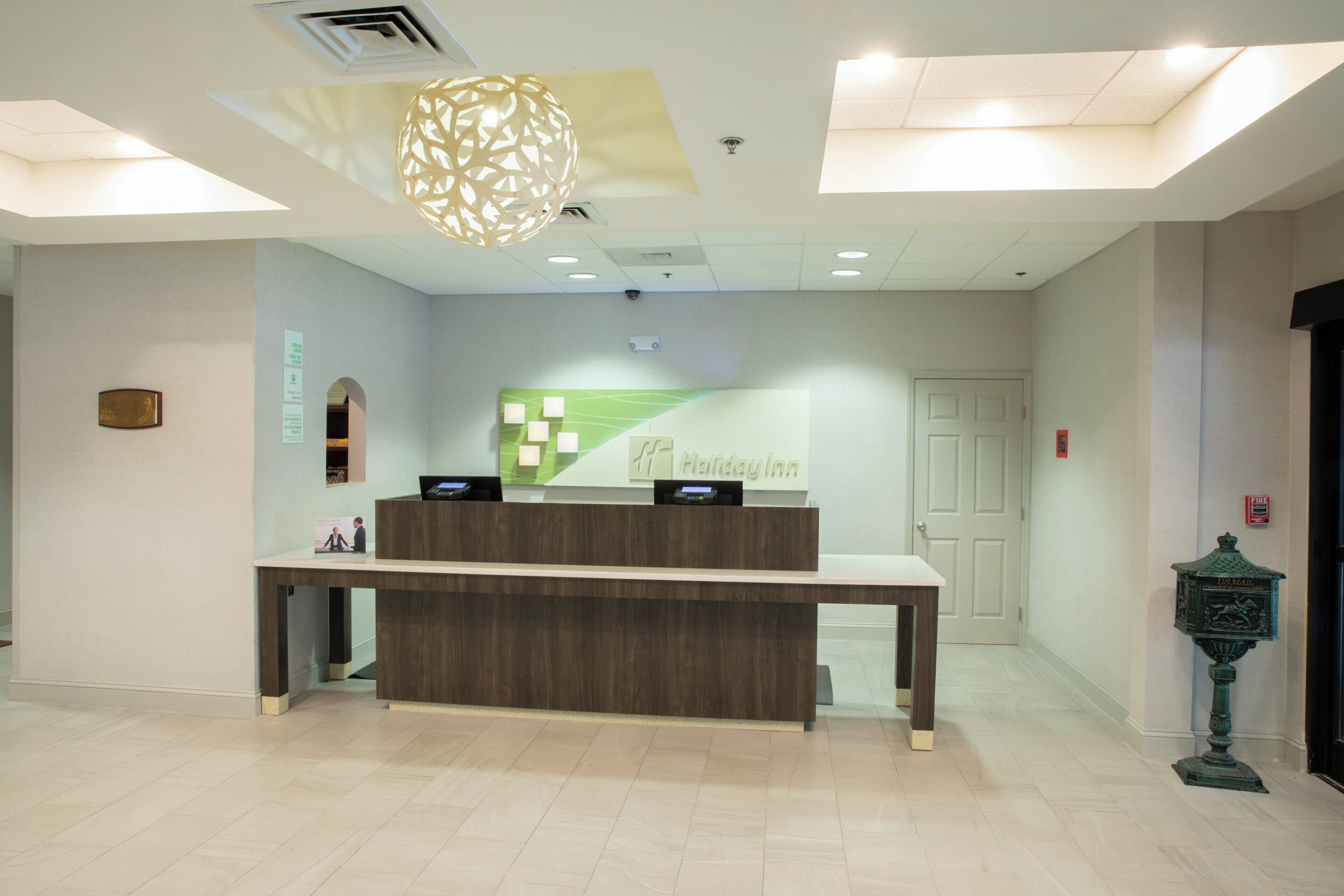 Una recepción con una pared verde y un cartel que dice 'Holiday Inn'.