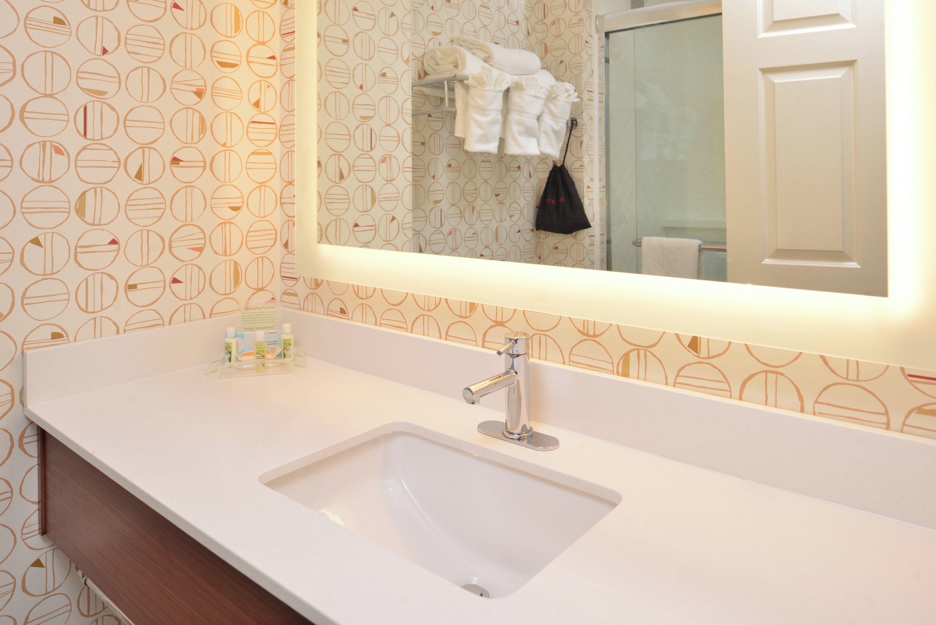 Une salle de bain avec un lavabo blanc, un miroir et un porte-serviettes.