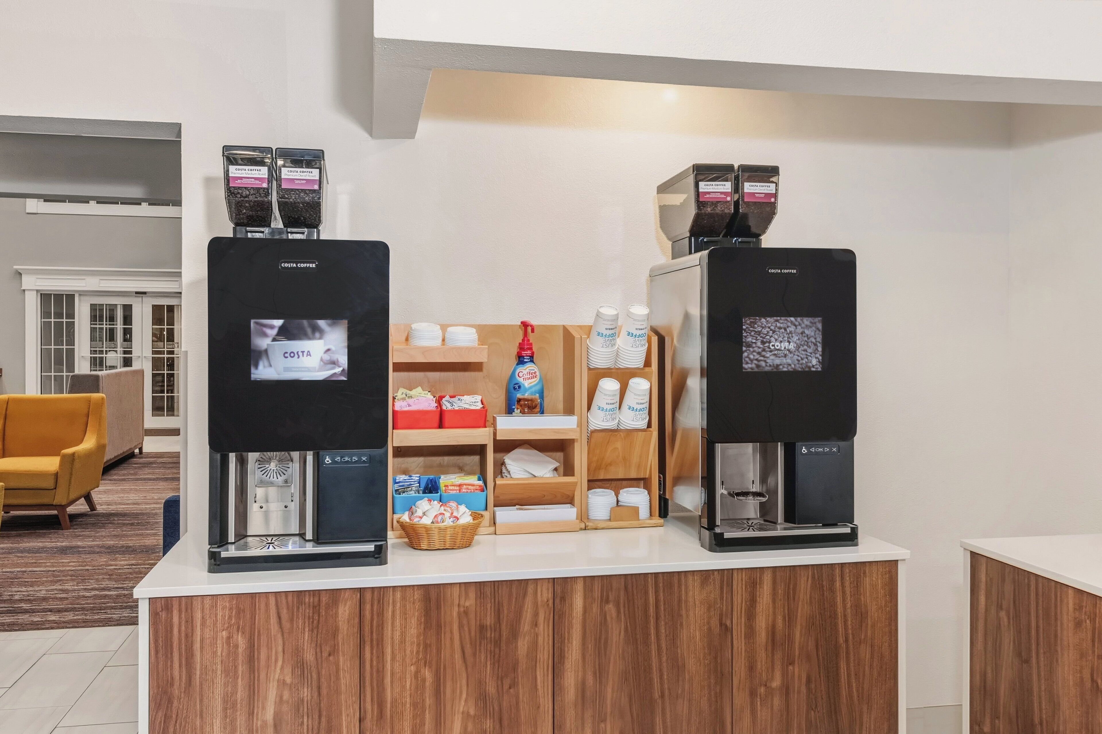 Un espace dédié au café, équipé de deux machines à expresso, d’un moulin à café et de divers accessoires liés au café.
