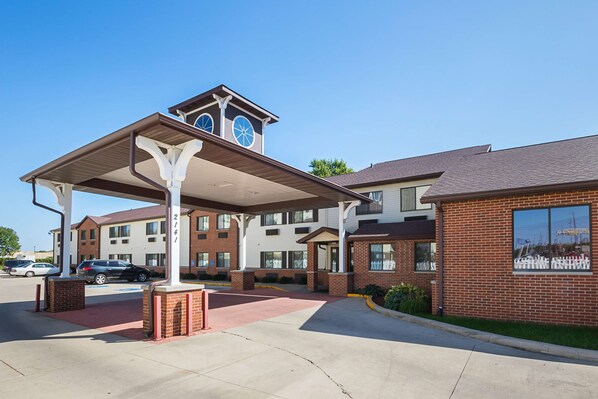 A hotel with a covered entrance, a brick building, and a clock tower. - Motel 6 Waterloo, IA - Crossroads Mall - Cedar Falls (Waterloo)