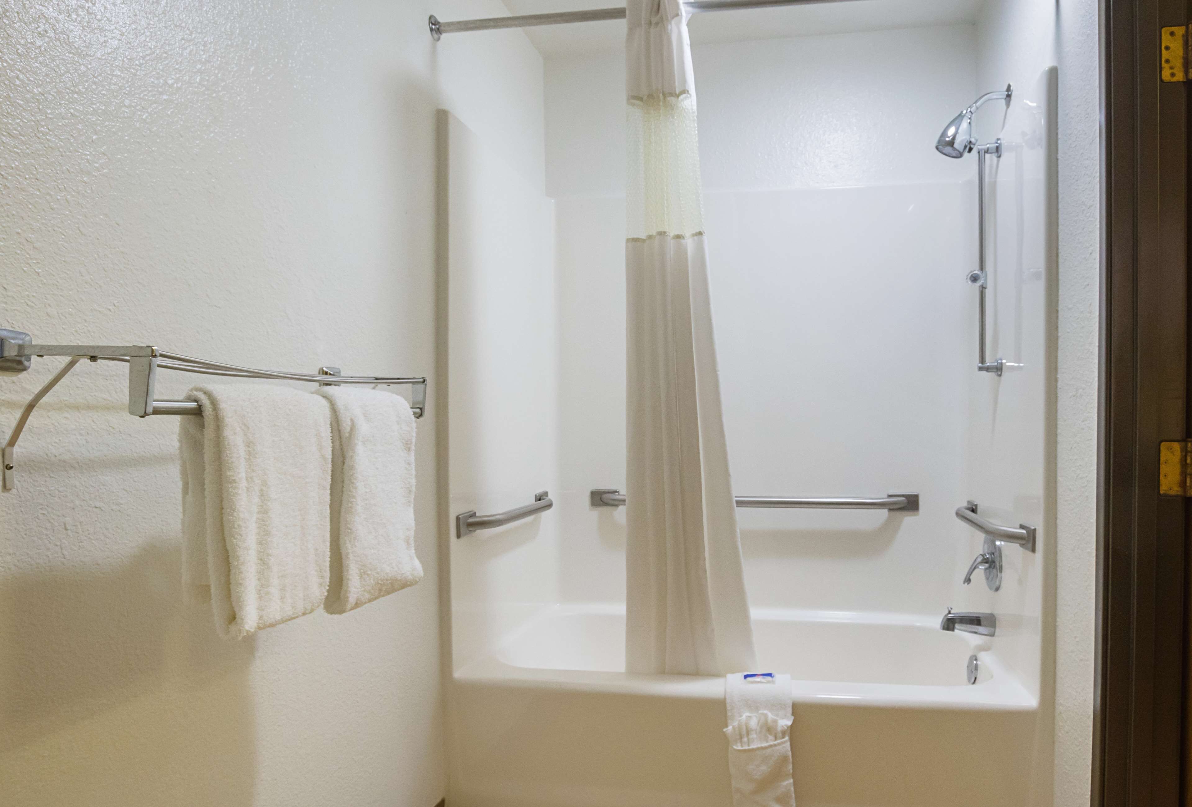 Ein Badezimmer mit einer Badewanne, einer Dusche und einem Handtuchhalter mit zwei Handtüchern.