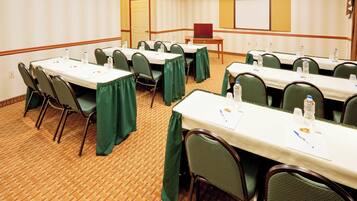 A conference room with multiple tables, chairs, and a whiteboard.