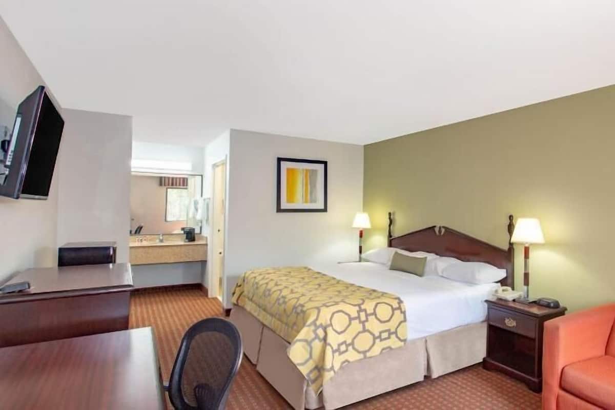 Une chambre d’hôtel équipée d’un lit, d’un bureau, d’une chaise et d’un téléviseur.