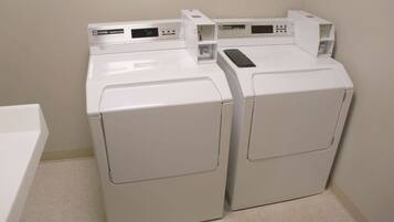 A laundry area with two white front-loading washing machines.