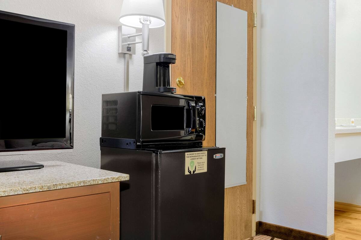 A compact kitchenette with a refrigerator, microwave, and coffee maker.