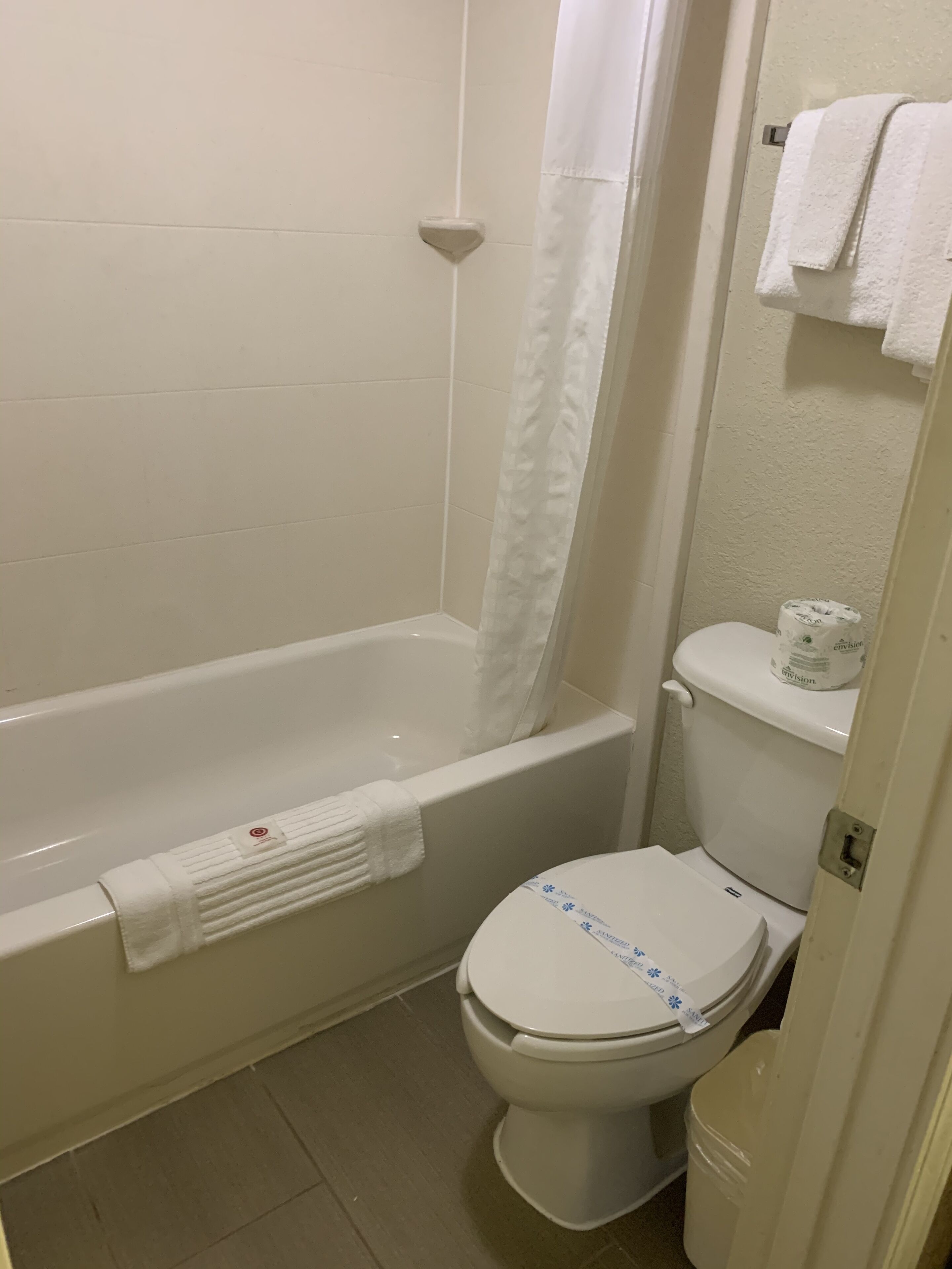 Une salle de bain avec une baignoire, des toilettes et un rideau de douche.
