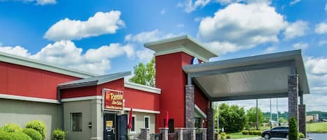 A restaurant with a red exterior and a covered entrance.