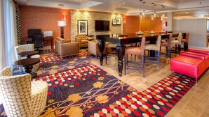 A hotel lobby with a bar area, seating, and a piano. - Hampton Inn Fremont (Fremont)