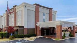 A hotel with a brick facade, a welcoming entrance, and an American flag. - Hampton Inn Memphis-Southwind (Memphis)