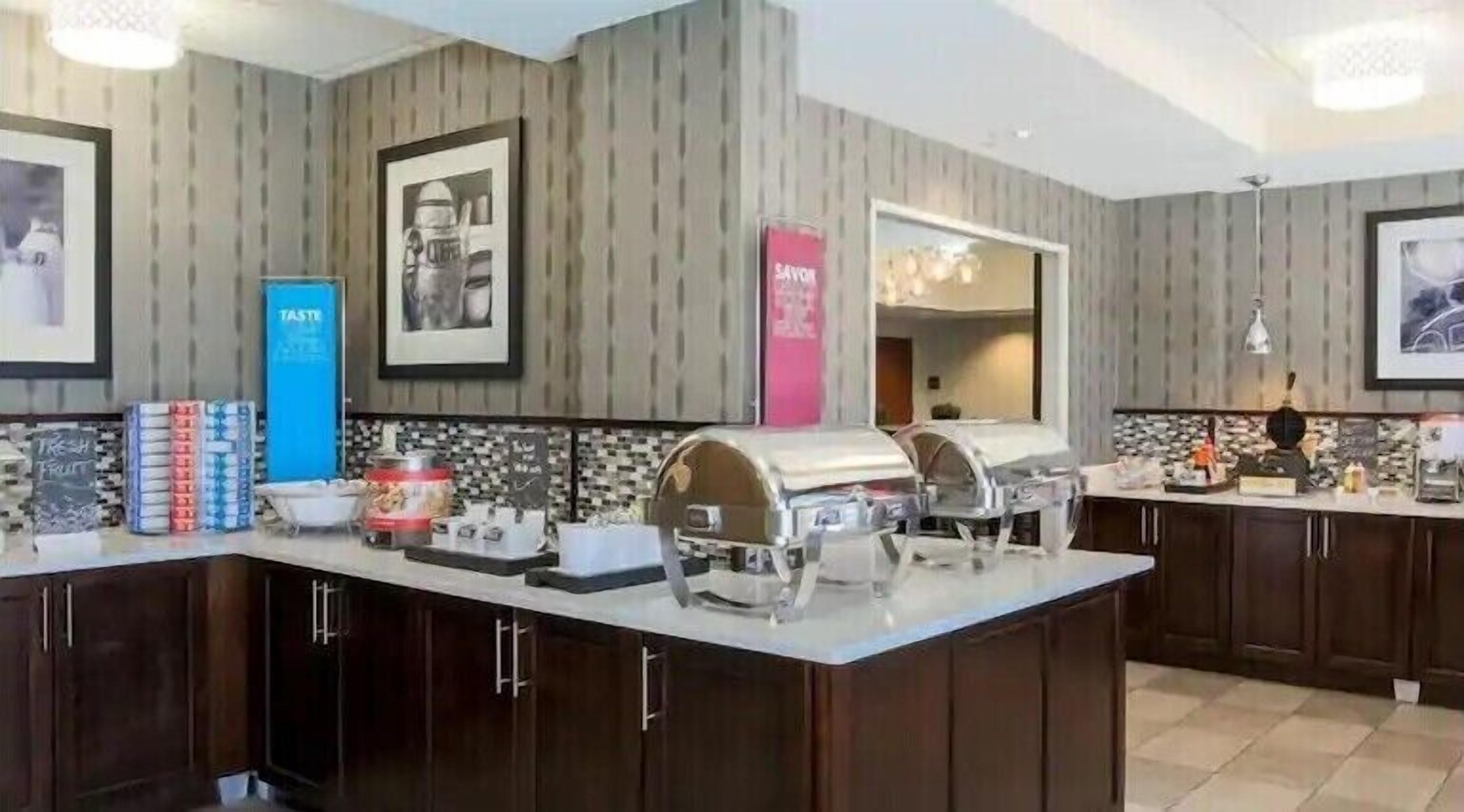 A modern kitchen with a central island, dark wooden cabinets, and a tiled backsplash.