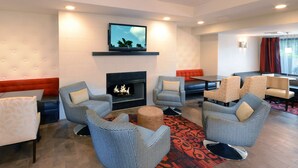Un salon moderne doté d’une cheminée, de sièges confortables et d’un téléviseur.