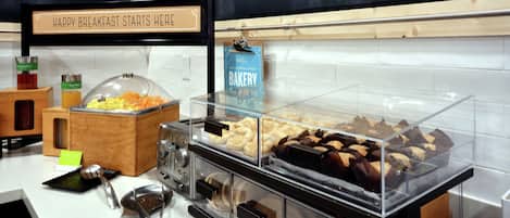 Un buffet de petit-déjeuner proposant une variété d’aliments, agrémenté d’une pancarte sur laquelle on peut lire : « C’EST ICI QUE COMMENCE UN EXCELLENT PETIT-DÉJEUNER ».