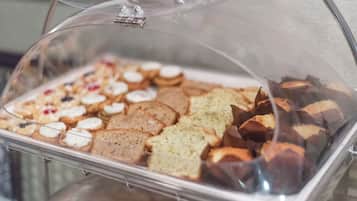 Una vitrina con diversas opciones de repostería, incluyendo galletas y pasteles.