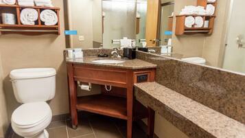A bathroom with a sink, toilet, and towel storage.