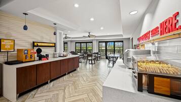 A breakfast area with a counter, seating, and a buffet.