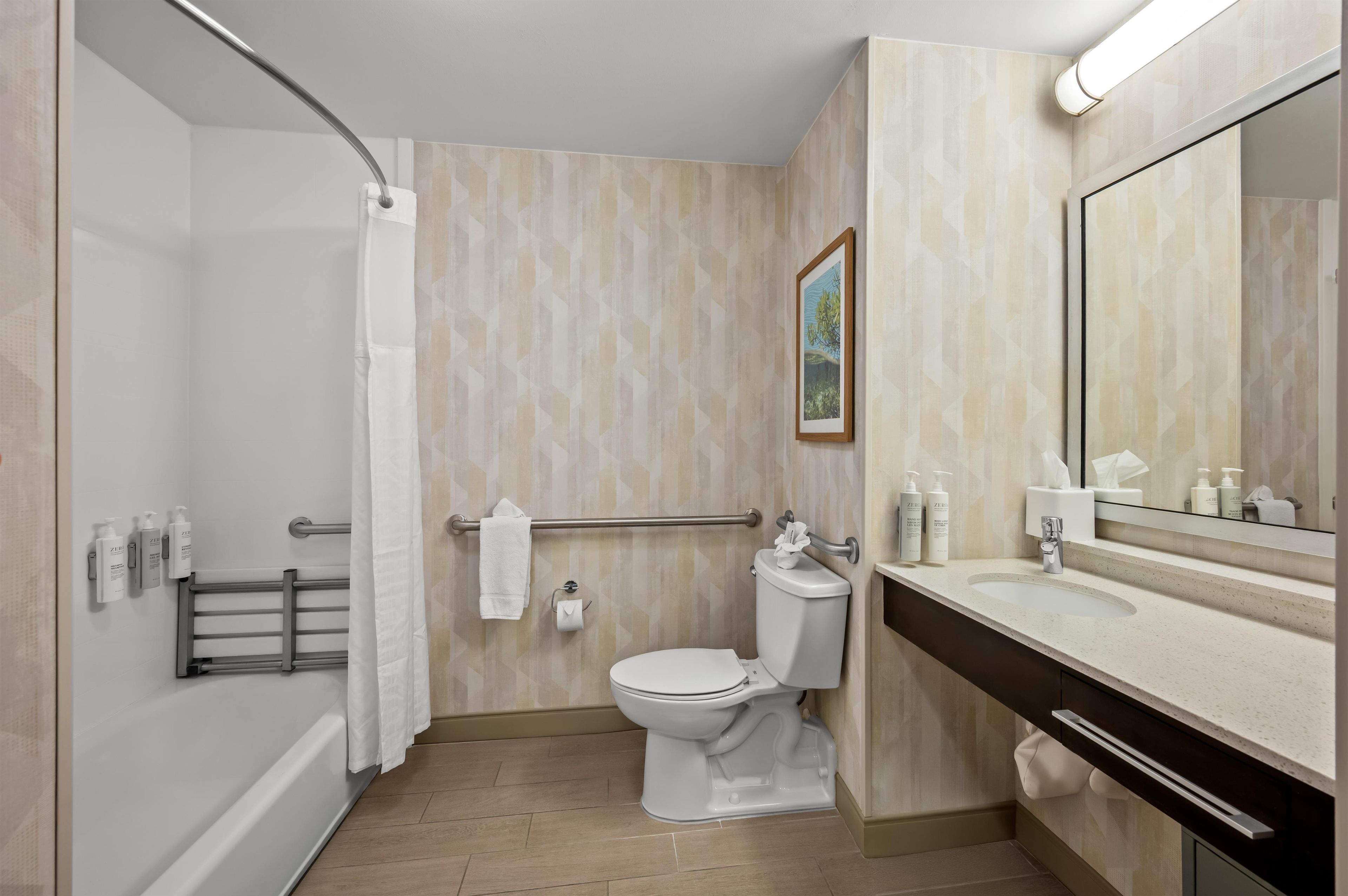 A modern bathroom with a shower, toilet, and vanity.