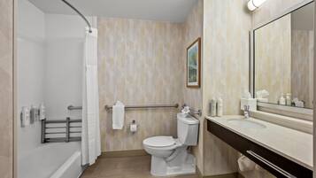 A modern bathroom with a shower, toilet, and vanity.