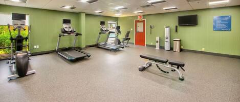 A fitness center with treadmills, a bench, and exercise equipment.