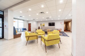 A lobby with a seating area, a television, and a fire alarm. - Hampton Inn Winchester N/Conference Center, VA (Winchester)
