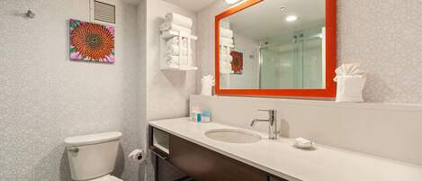 A modern bathroom with a toilet, sink, and shower.