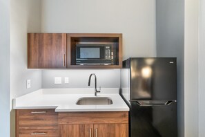 A kitchen with a microwave, refrigerator, sink, and wooden cabinets. - Hampton Inn Winchester N/Conference Center, VA (Winchester)