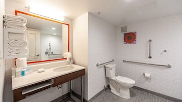 A modern bathroom with a sink, mirror, and toilet.