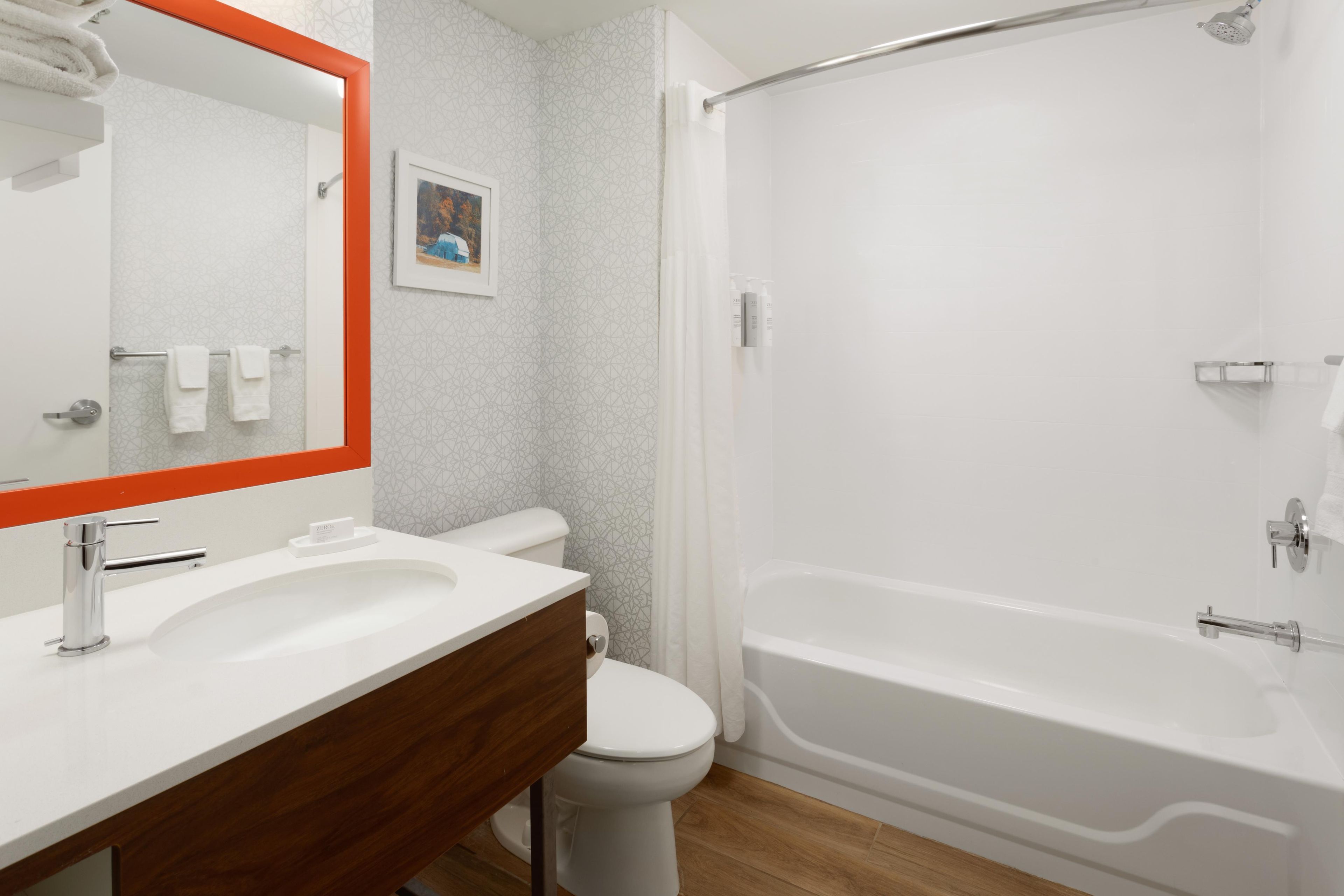 A bathroom with a white sink, a toilet, a bathtub, and a shower.