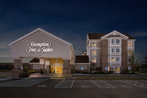A Hampton Inn & Suites hotel with a large entrance, parking lot, and handicap-accessible signs.